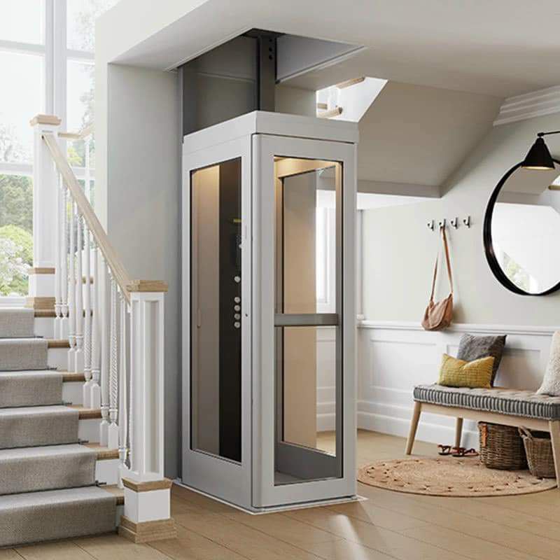 Thang máy gia đình mini cabin trắng cạnh cầu thang